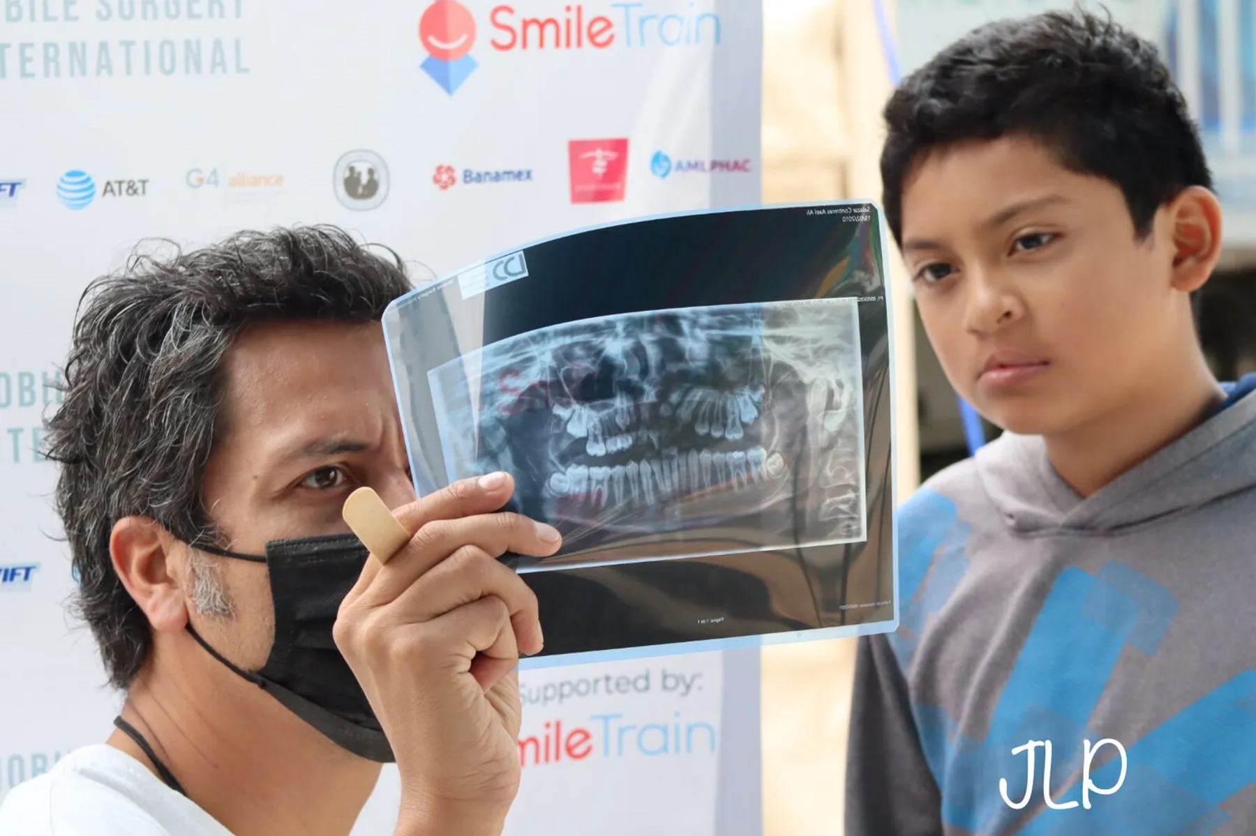 Dr. Nico Sierra examina una radiografía panorámica junto a un niño que espera su valoración