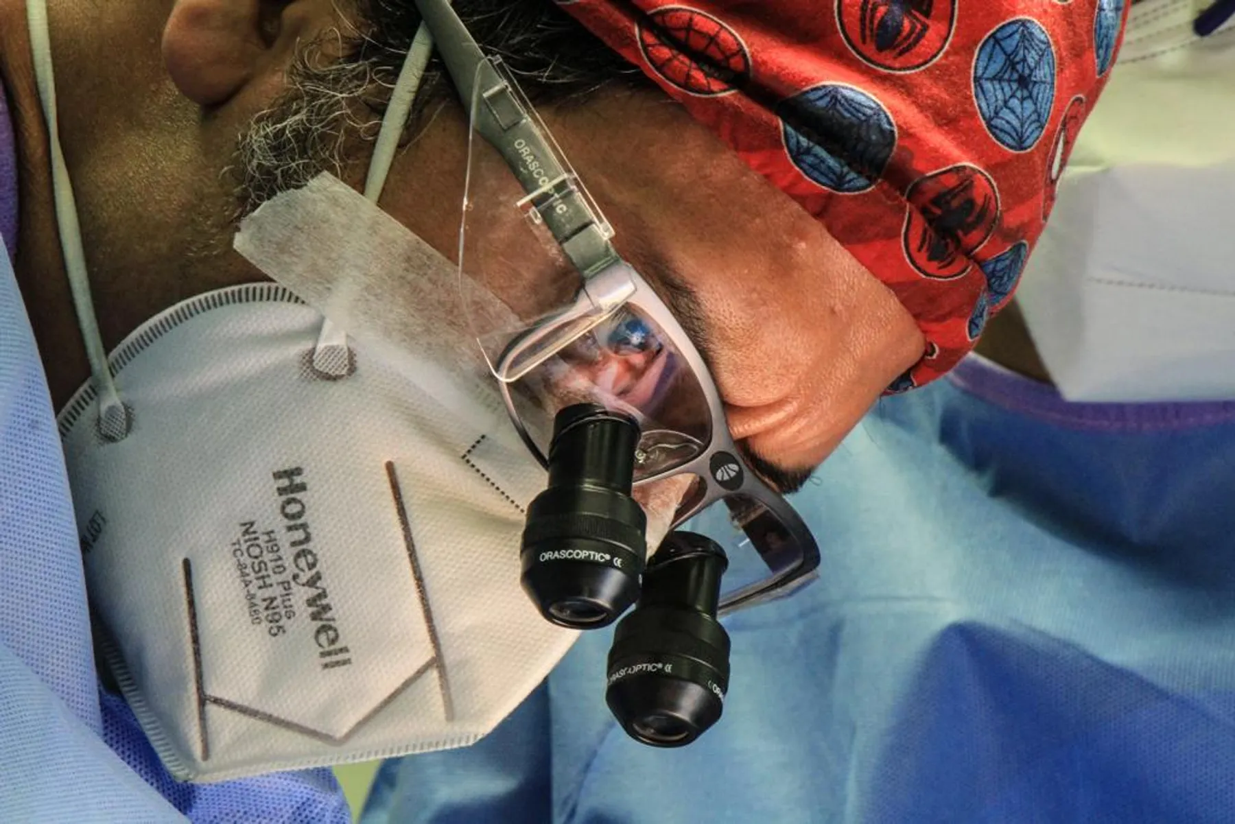 Primer plano del Dr. Nico Sierra operando con gafas de aumento quirúrgicas y mascarilla